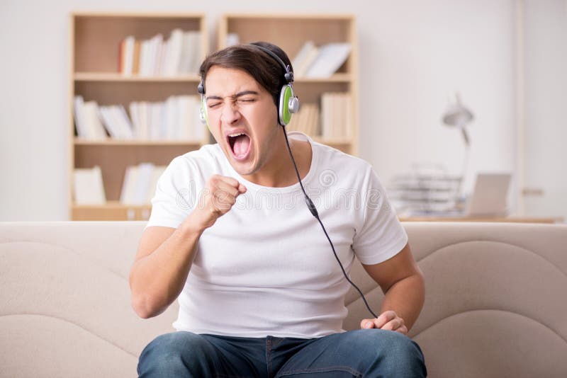 O homem que escuta a música em casa imagens de stock O homem que escuta a música em casa imagens de stock