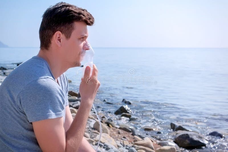 O homem retrato usa máscara de inalador de nebulizador para o tratamento de fibrose à margem imagens de stock O homem retrato usa máscara de inalador de nebulizador para o tratamento de fibrose à margem imagens de stock
