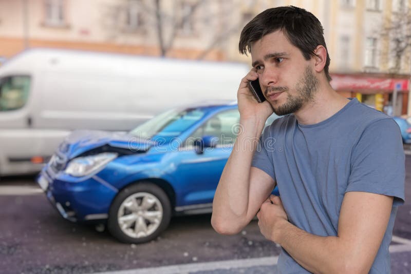 O homem triste está chamando ao auxílio após o acidente de trânsito imagem de stock royalty free O homem triste está chamando ao auxílio após o acidente de trânsito imagem de stock royalty free