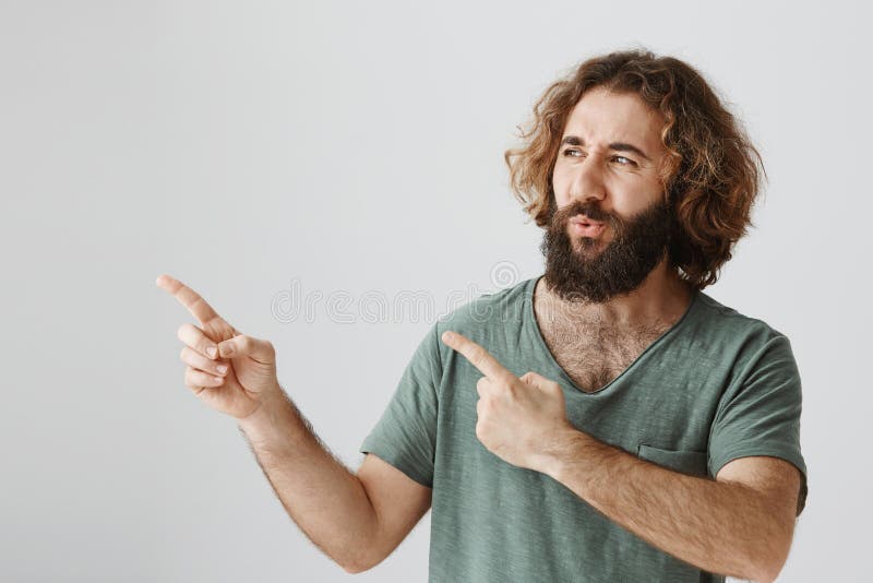 O homem é imprimido com o carro de esportes fresco Tiro interno do indivíduo oriental farpado surpreendido com o cabelo encaracol fotografia de stock O homem é imprimido com o carro de esportes fresco Tiro interno do indivíduo oriental farpado surpreendido com o cabelo encaracol fotografia de stock