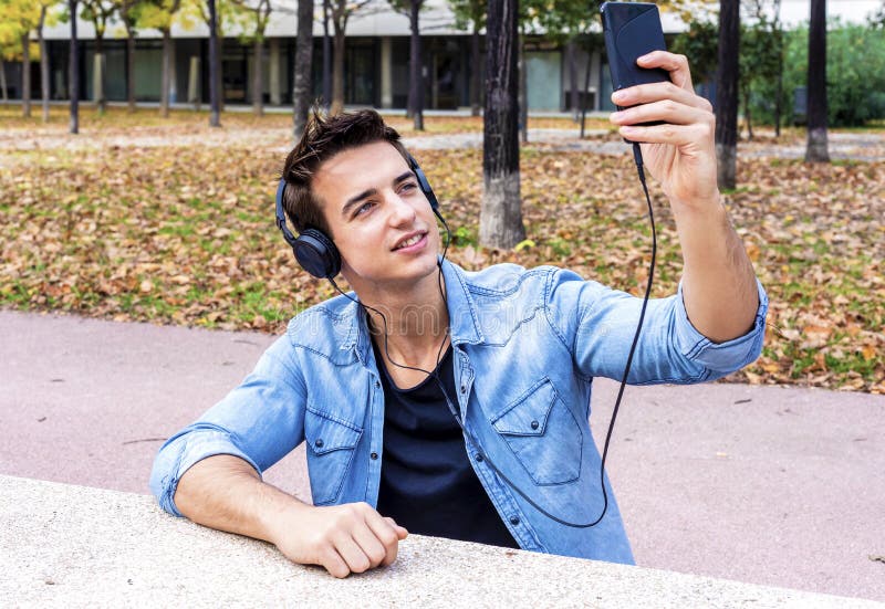 O indivíduo novo está fazendo o selfie em uma câmera Está vestindo o tre ocasional fotos de stock O indivíduo novo está fazendo o selfie em uma câmera Está vestindo o tre ocasional fotos de stock