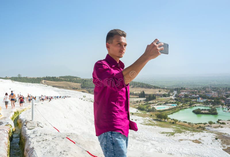 O indivíduo novo, turista, toma imagens com seu Pa da opinião do telefone celular fotografia de stock royalty free O indivíduo novo, turista, toma imagens com seu Pa da opinião do telefone celular fotografia de stock royalty free