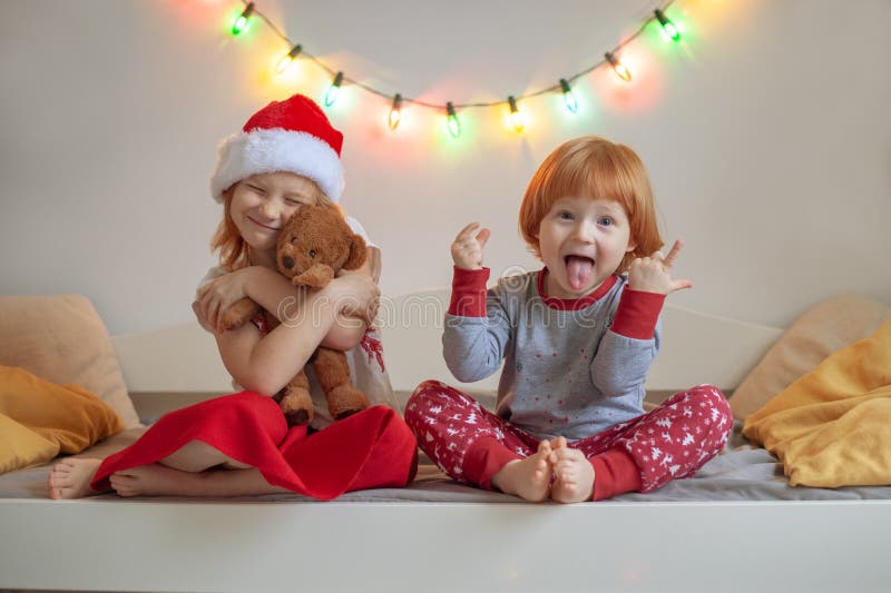 O irmão e a irmã sentam-se em uma cama imagem de stock royalty free