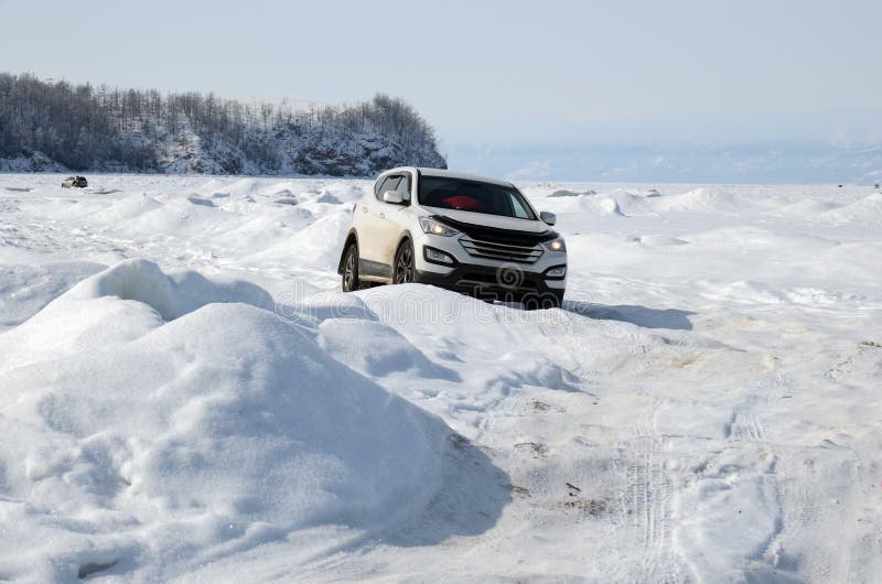 Jeep goes through uneven ice with crackes and bumps of Lake Baikal in winter. Jeep goes through uneven ice with crackes and bumps of Lake Baikal in winter