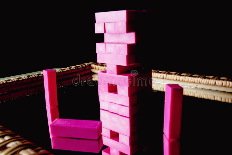 The pink plastic jenga children&#x27;s game started as a birthday present on a wooden mirror. The pink plastic jenga children&#x27;s game started as a birthday present on a wooden mirror.