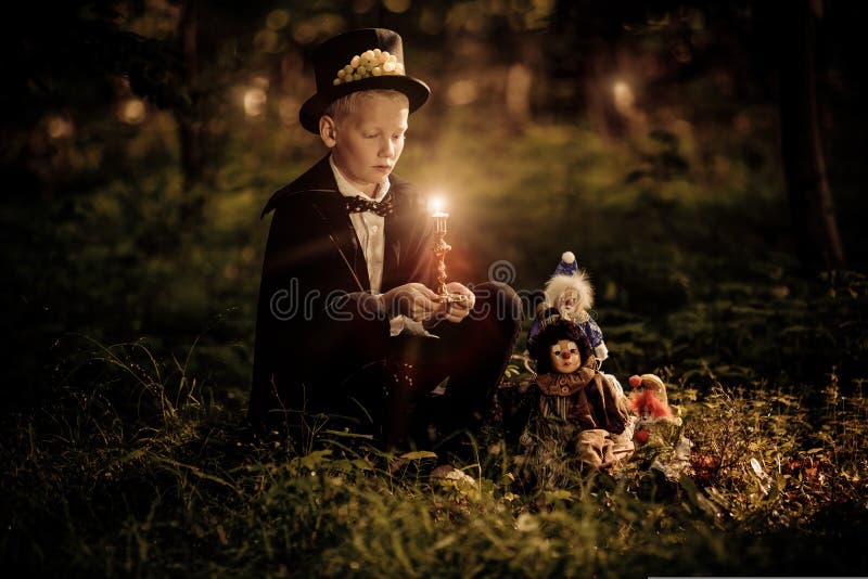 O laço e o chapéu alto vestindo do menino guardam a vela fotografia de stock royalty free O laço e o chapéu alto vestindo do menino guardam a vela fotografia de stock royalty free