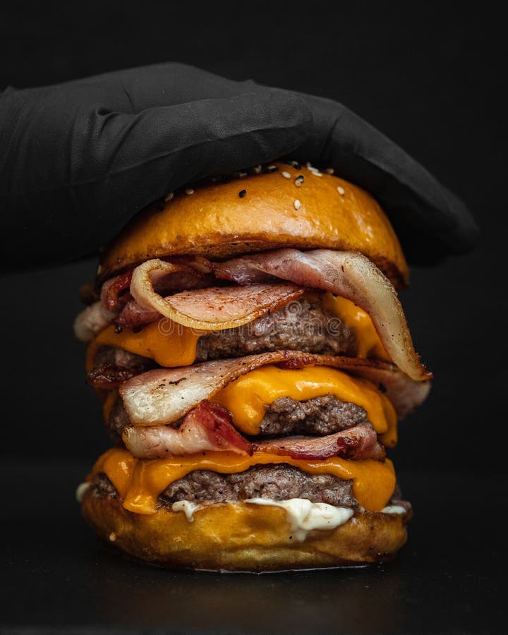 O lovitură de closeup a unui burger gigant delicios cu apă gură cu șuncă topită și carne de vită prăjită stock photos