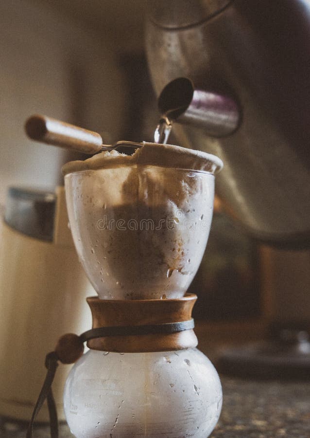 O lovitură verticală a unui proces de preparare a cafelei un ceainic turnând apă în cana specială stock photography