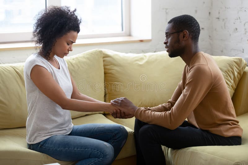 O marido americano africano ajuda a confortar a esposa