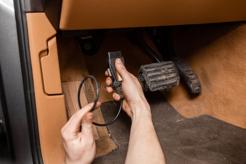 O mecânico conecta o computador à máquina O mecânico de carro mantém um veículo com a ajuda de uma tabuleta diagnóstica imagem de stock O mecânico conecta o computador à máquina O mecânico de carro mantém um veículo com a ajuda de uma tabuleta diagnóstica imagem de stock