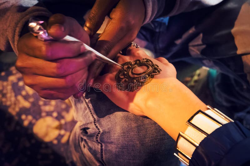 O mehndi mestre tira a hena em uma mão fêmea fotos de stock O mehndi mestre tira a hena em uma mão fêmea fotos de stock