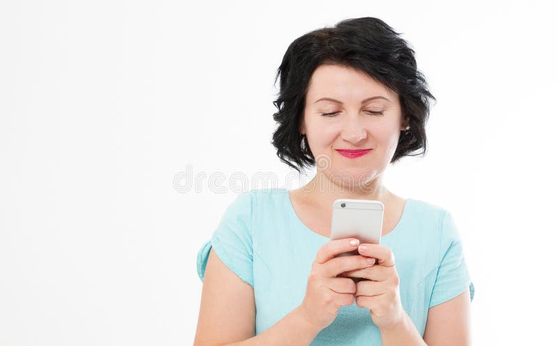 O meio feliz envelheceu a mulher moreno que olha a foto das imagens no telefone celular isolado no espaço branco da cópia do fund fotografia de stock O meio feliz envelheceu a mulher moreno que olha a foto das imagens no telefone celular isolado no espaço branco da cópia do fund fotografia de stock