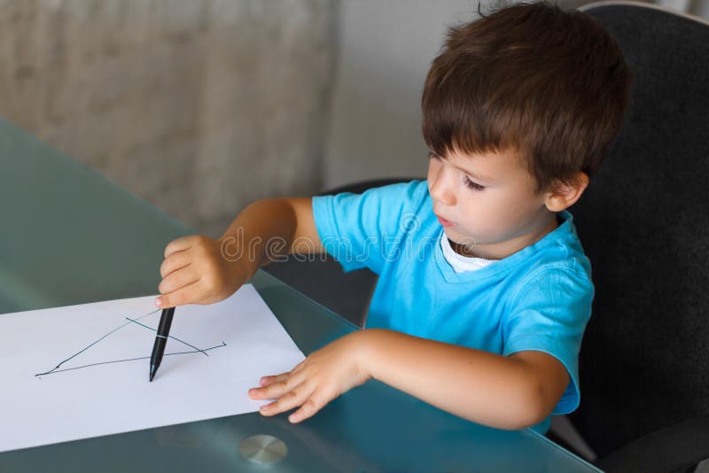 O menino da criança em idade pré-escolar aprende letras da escrita fotografia de stock O menino da criança em idade pré-escolar aprende letras da escrita fotografia de stock