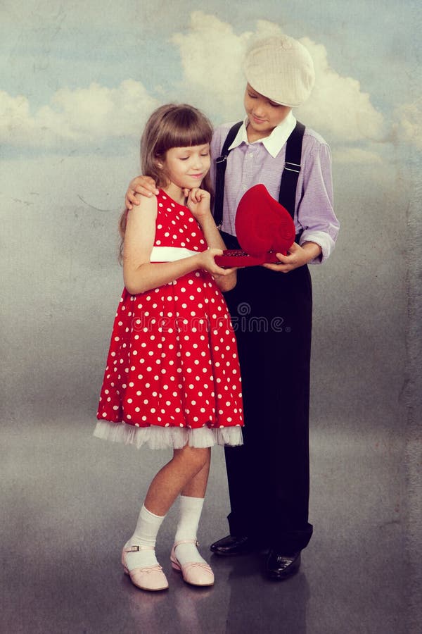 O menino dá grânulos à menina Estilo retro imagem de stock royalty free O menino dá grânulos à menina Estilo retro imagem de stock royalty free