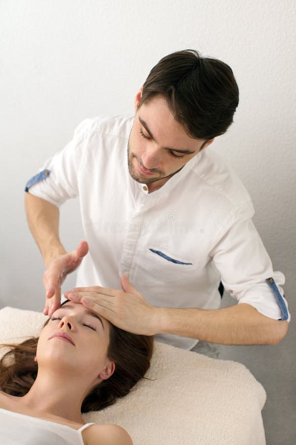 O mestre faz massagens ao cliente no fundo branco foto de stock O mestre faz massagens ao cliente no fundo branco foto de stock