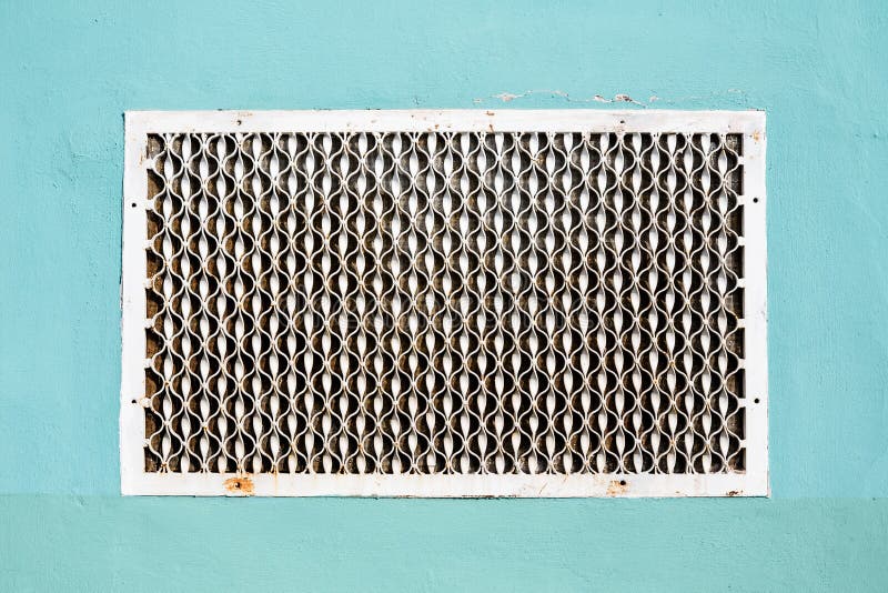 O metal velho modelou a grade da ventilação na parede emplastrada imagem de stock O metal velho modelou a grade da ventilação na parede emplastrada imagem de stock