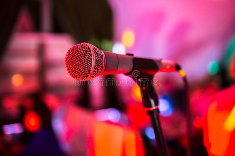 O microfone está na fase em um clube noturno A luz brilhante do clube brilha no MIC Desempenhos no clube noturno fotos de stock royalty free O microfone está na fase em um clube noturno A luz brilhante do clube brilha no MIC Desempenhos no clube noturno fotos de stock royalty free