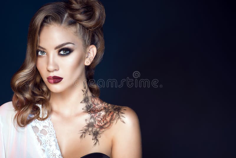 O modelo com artístico compõe e penteado Arte corporal em seu ombro Conceito ideal da mulher fotografia de stock O modelo com artístico compõe e penteado Arte corporal em seu ombro Conceito ideal da mulher fotografia de stock