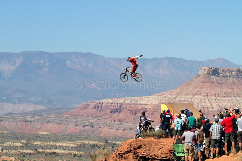 Ciclista de montanha salta penhasco e multidão assiste imagem de stock