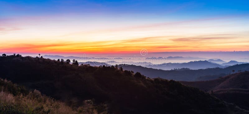 O nascer do sol colorido bonito com névoa branca cobriu a cordilheira das camadas no amanhecer fotografia de stock O nascer do sol colorido bonito com névoa branca cobriu a cordilheira das camadas no amanhecer fotografia de stock