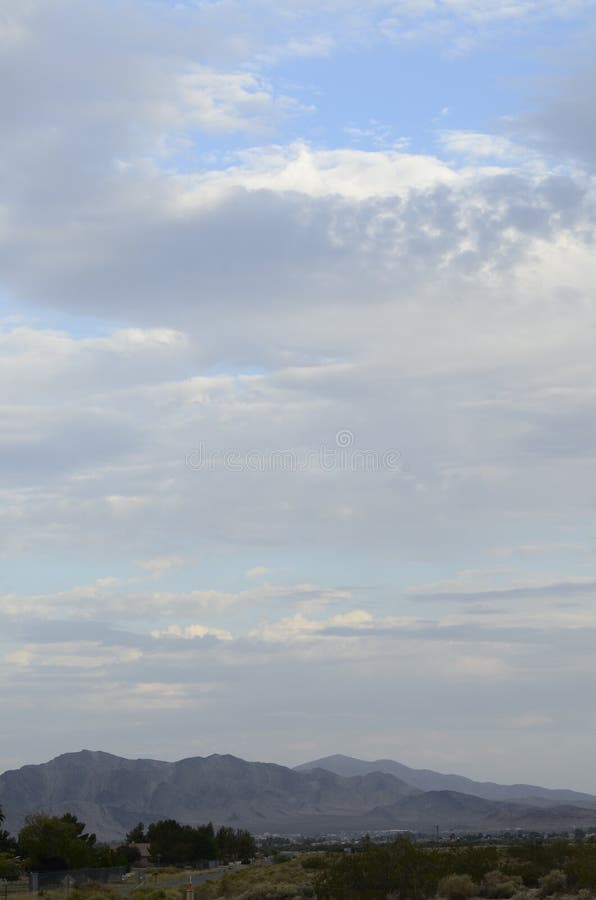 O nascer do sol nubla-se sobre a cidade Pahrump do vale das montanhas do deserto de Mojave, Nevada, EUA imagem de stock O nascer do sol nubla-se sobre a cidade Pahrump do vale das montanhas do deserto de Mojave, Nevada, EUA imagem de stock