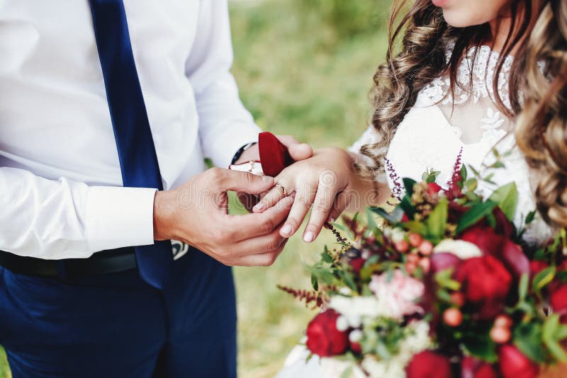 O Noivo Coloca a Aliança De Casamento No Dedo Da Noiva. Bouquet De Casamento  Foto de Stock - Imagem de peônia, luxo: 206947318