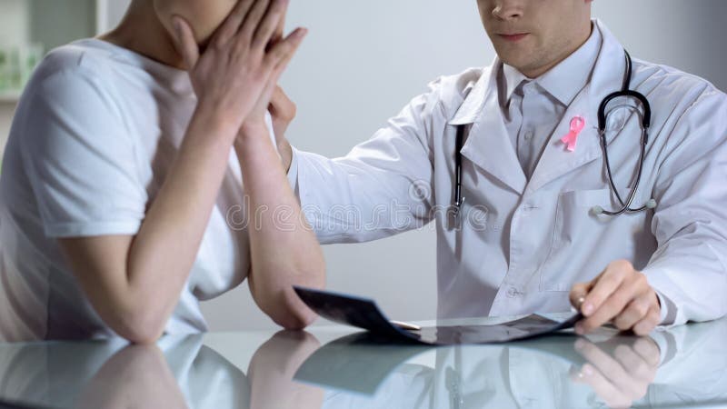 O oncologista informa a jovem senhora sobre o câncer da mama, resultado mau do mamograma fotografia de stock royalty free O oncologista informa a jovem senhora sobre o câncer da mama, resultado mau do mamograma fotografia de stock royalty free