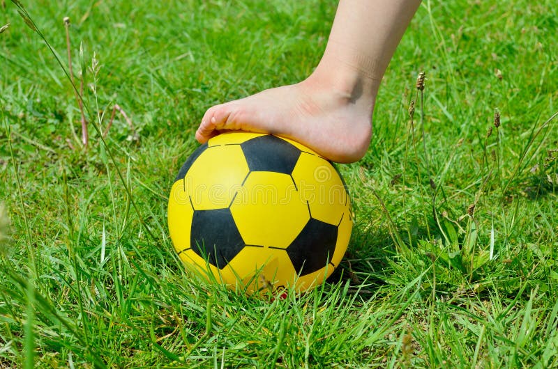 Pés Em Tênis E Bola De Futebol Ao Sol. Jogo Infantil. Foto de Stock -  Imagem de esfera, pés: 192406154
