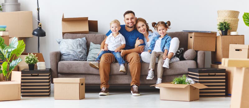 Happy family mother father and children move to a new apartment and unpack boxes. Happy family mother father and children move to a new apartment and unpack boxes