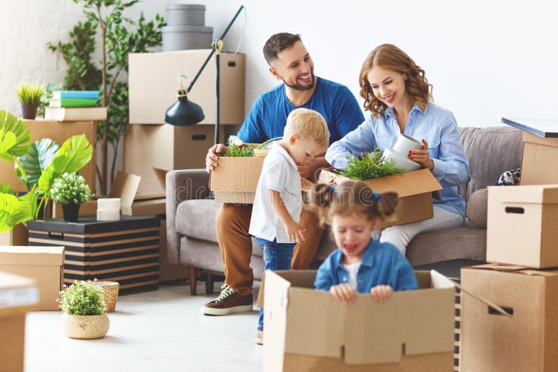 Happy family mother father and children move to a new apartment and unpack boxes. Happy family mother father and children move to a new apartment and unpack boxes