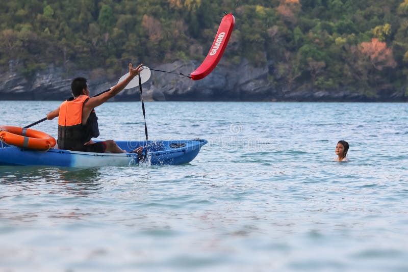 O pai e a filha asi?ticos s?o de ensino e de forma??o o protetor ou o salvamento de vida na praia foto de stock O pai e a filha asi?ticos s?o de ensino e de forma??o o protetor ou o salvamento de vida na praia foto de stock