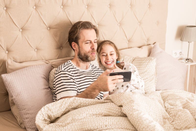 O pai e a filha tomam a foto do selfie com smartphone foto de stock O pai e a filha tomam a foto do selfie com smartphone foto de stock