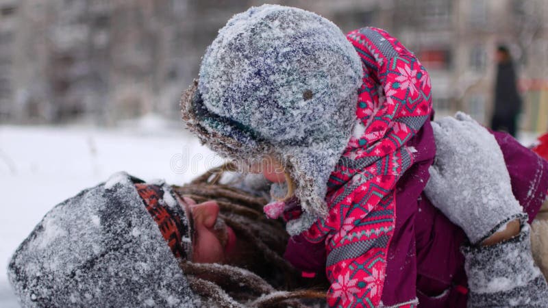 O paizinho novo considerável e sua filha bonito pequena estão tendo o divertimento exterior no inverno Apreciando o tempo de gast