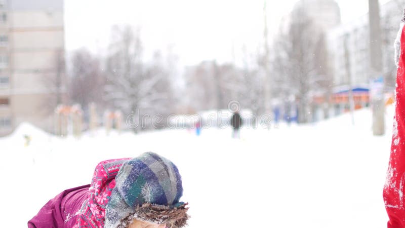 O paizinho novo considerável e sua filha bonito pequena estão tendo o divertimento exterior no inverno Apreciando o tempo de gast