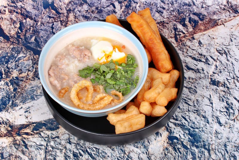 O papa de aveia do arroz do ` s da carne de porco serviu com a vara fritada da massa fotos de stock O papa de aveia do arroz do ` s da carne de porco serviu com a vara fritada da massa fotos de stock