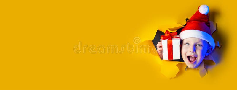 O Papai Noel alegre dá um presente, saindo do fundo amarelo brilhante fotografia de stock royalty free O Papai Noel alegre dá um presente, saindo do fundo amarelo brilhante fotografia de stock royalty free