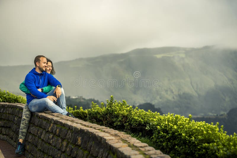 O par novo e atrativo é de aperto e de assento na borda do ponto de vista foto de stock royalty free O par novo e atrativo é de aperto e de assento na borda do ponto de vista foto de stock royalty free
