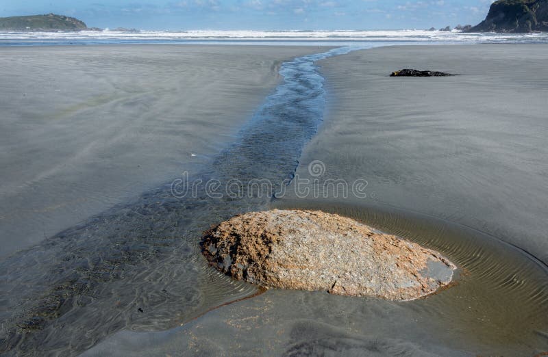 O passado de fluxo do córrego pequeno expôs a pedra na praia intacto abandonada