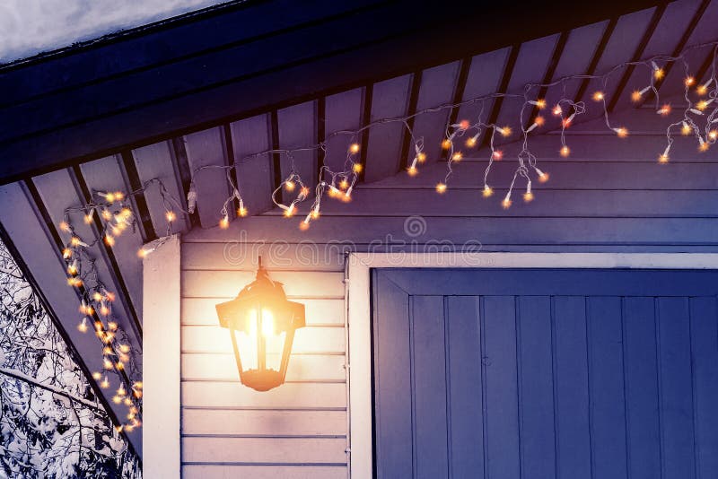 O patamar da casa é decorado no estilo escandinavo tradicional com uma lanterna e luzes de Natal - conceito do calor da casa