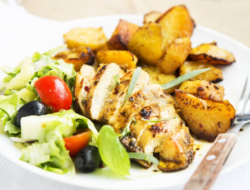 O peito de frango Roasted com batatas doces e a salada decoram imagens de stock royalty free O peito de frango Roasted com batatas doces e a salada decoram imagens de stock royalty free