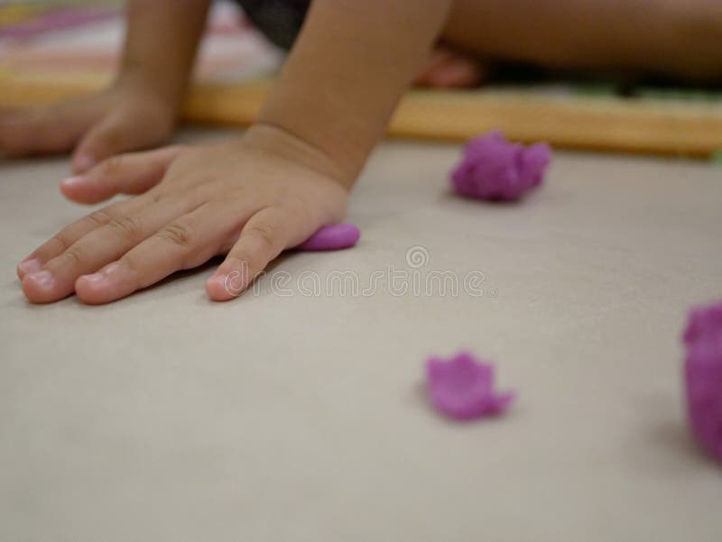 O ` pequeno s do bebê entrega o jogo da massa do jogo no assoalho fotografia de stock O ` pequeno s do bebê entrega o jogo da massa do jogo no assoalho fotografia de stock