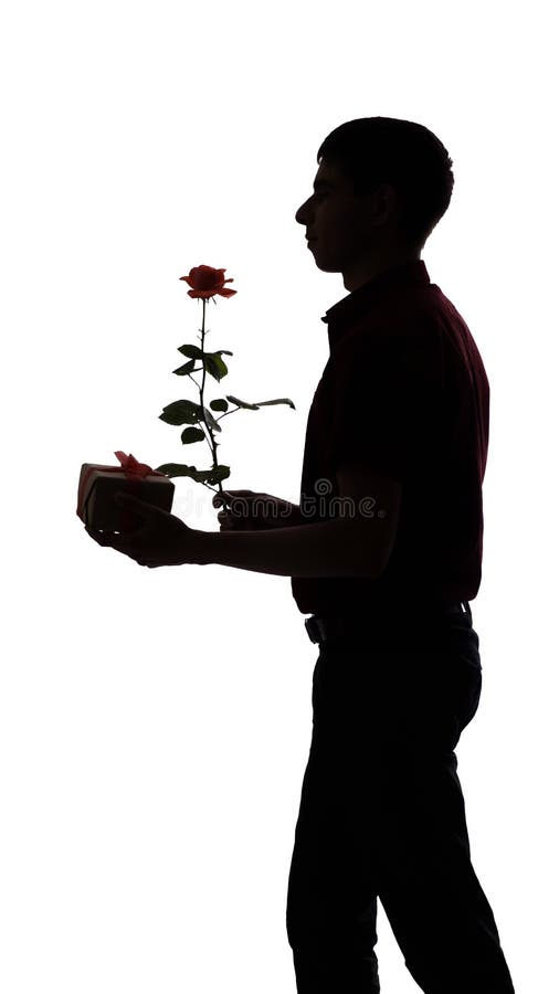 O perfil da silhueta de um homem com uma caixa de presente e uma flor cor-de-rosa para seu amado, o indivíduo felicita no fundo i imagem de stock royalty free O perfil da silhueta de um homem com uma caixa de presente e uma flor cor-de-rosa para seu amado, o indivíduo felicita no fundo i imagem de stock royalty free