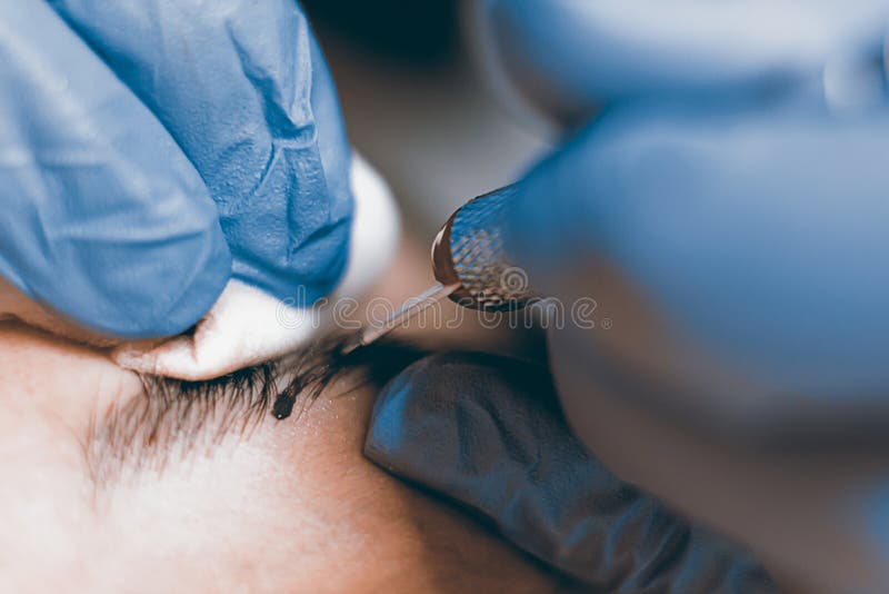 O Permanent compõe Cosmetologist que aplica a composição permanente em ey fotografia de stock O Permanent compõe Cosmetologist que aplica a composição permanente em ey fotografia de stock