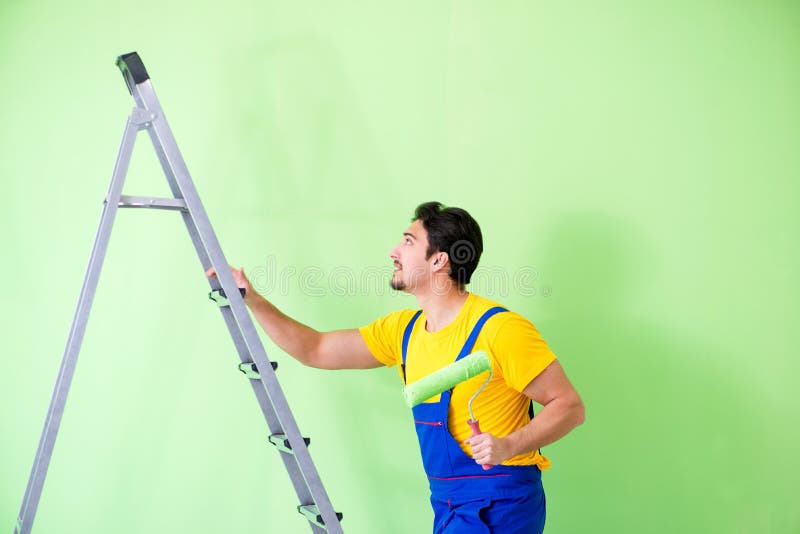 O pintor novo que faz a renovação em casa fotografia de stock O pintor novo que faz a renovação em casa fotografia de stock