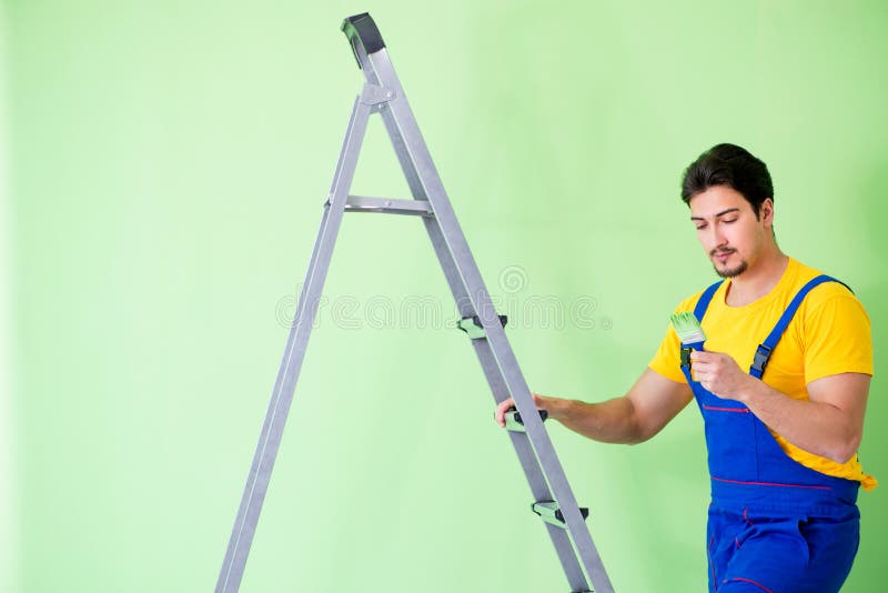 O pintor novo que faz a renovação em casa fotos de stock O pintor novo que faz a renovação em casa fotos de stock