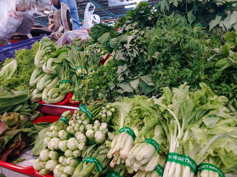 O prezentare colorată a legumelor verzi proaspete pe piața locală asiatică stock photos