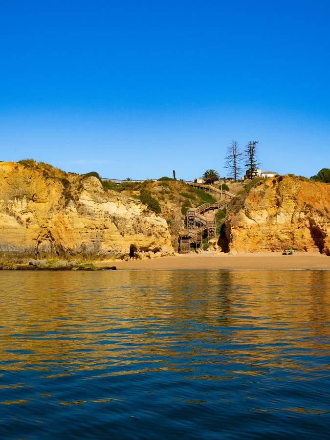 O priveliște frumoasă a stâncilor și a plajei nisipoase din apă în ziua însorită. Coasta Algarve stock image