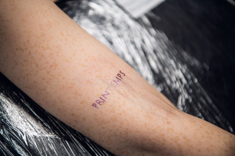 A Mão De Um Tatuador Uma Menina Com Tatuagens E Uma Tatuagem Recém-feita Na  Forma De Uma Palavra Na Mão De Uma Moça Imagem de Stock - Imagem de  manuscrito, arte: 205472765