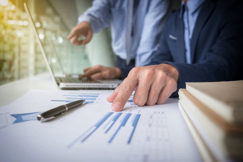 O processo dos trabalhos de equipa, homens de negócios entrega apontar no portátil e no docum imagem de stock royalty free