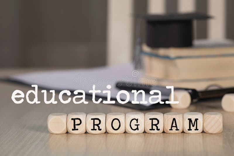 Words  EDUCATIONAL PROGRAM composed of wooden dices. Black graduate hat and books in the background. Closeup. Words  EDUCATIONAL PROGRAM composed of wooden dices. Black graduate hat and books in the background. Closeup